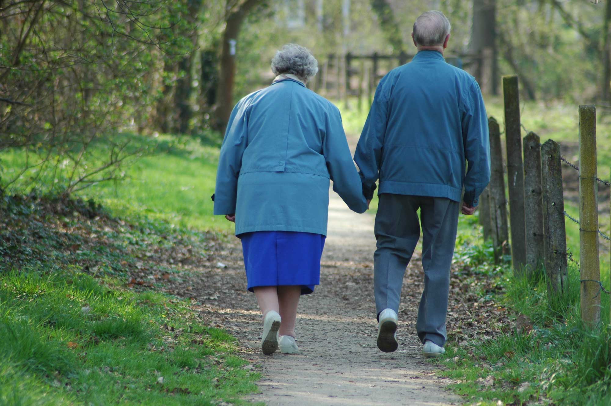 Elderly couple walking together holding hands